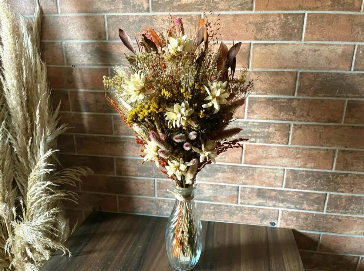Arranjo de flores desidratadas em vaso de vidro